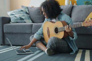estudo online de guitarra realizado em casa com notebook