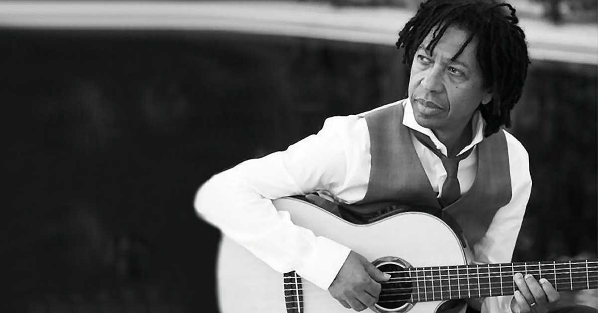 Retrato do cantor e compositor Djavan com seu violão, ícone da música brasileira.