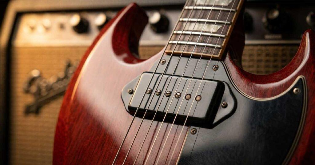 Foco em um captador P90 soapbar preto montado em uma guitarra Gibson SG cherry red.